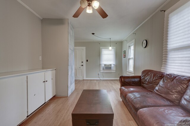 living room with ornamental molding, light hardwood / wood-style flooring, and ceiling fan