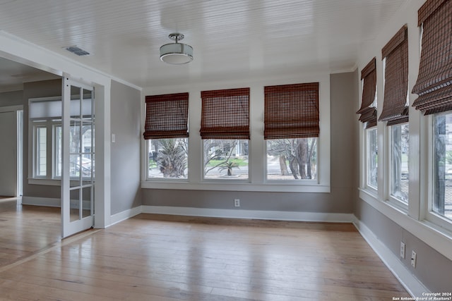 spare room with french doors, crown molding, and light wood-type flooring