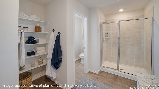 bathroom featuring hardwood / wood-style flooring, toilet, and an enclosed shower