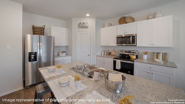 kitchen featuring light stone counters, white cabinetry, dark wood-type flooring, and appliances with stainless steel finishes