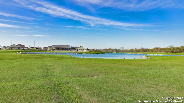 surrounding community featuring a water view and a lawn