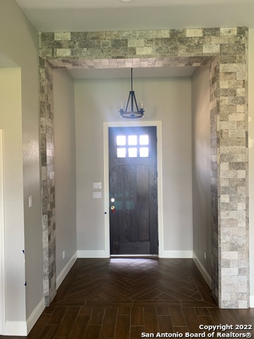 foyer entrance featuring dark parquet floors