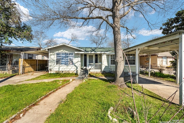 view of front of home featuring a porch, a carport, and a front lawn