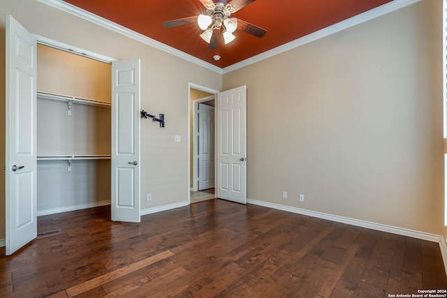 unfurnished bedroom with ceiling fan, crown molding, dark wood-type flooring, and a closet