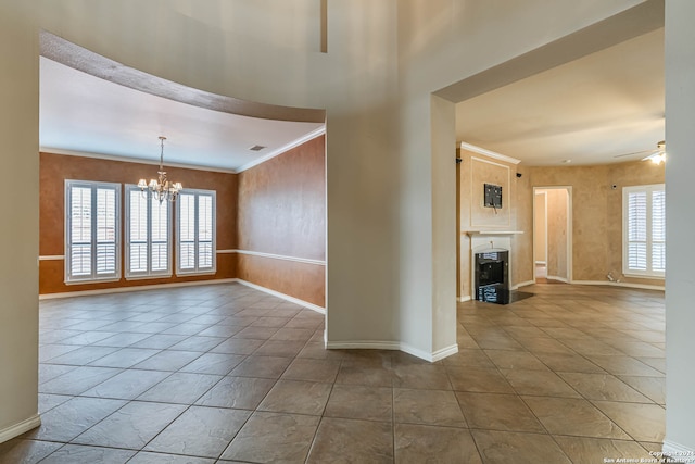 spare room with dark tile flooring and ceiling fan with notable chandelier