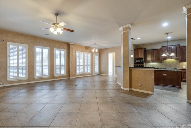 kitchen featuring backsplash, light tile floors, black microwave, ceiling fan, and decorative columns