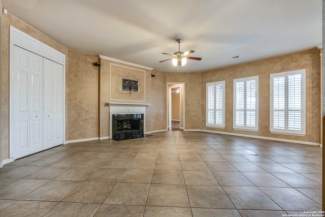 unfurnished living room featuring ceiling fan and light tile floors