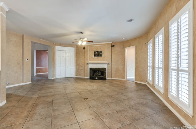 unfurnished living room featuring light tile flooring, a healthy amount of sunlight, and ceiling fan