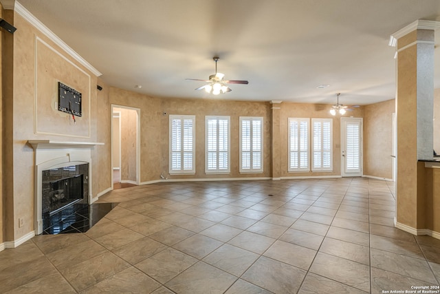 unfurnished living room with a high end fireplace, a healthy amount of sunlight, and ceiling fan