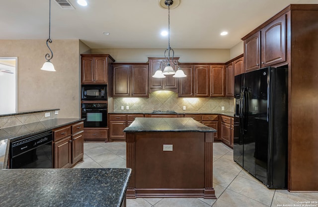 kitchen featuring pendant lighting, tasteful backsplash, a center island, and black appliances