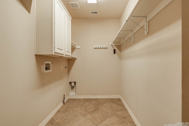 washroom featuring light tile floors, cabinets, hookup for an electric dryer, and gas dryer hookup