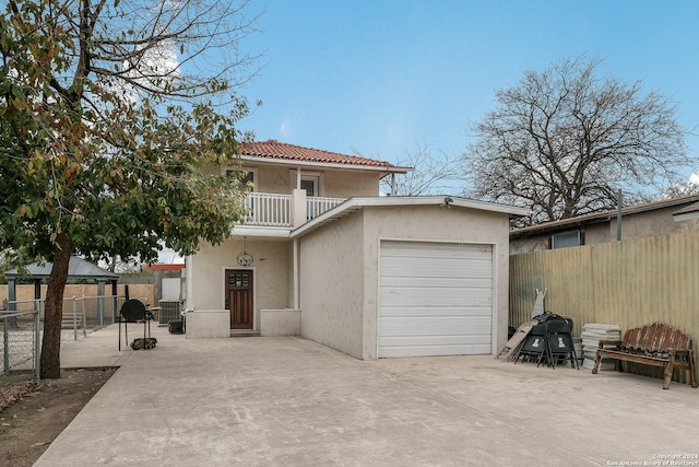 view of front of property featuring a balcony and a garage