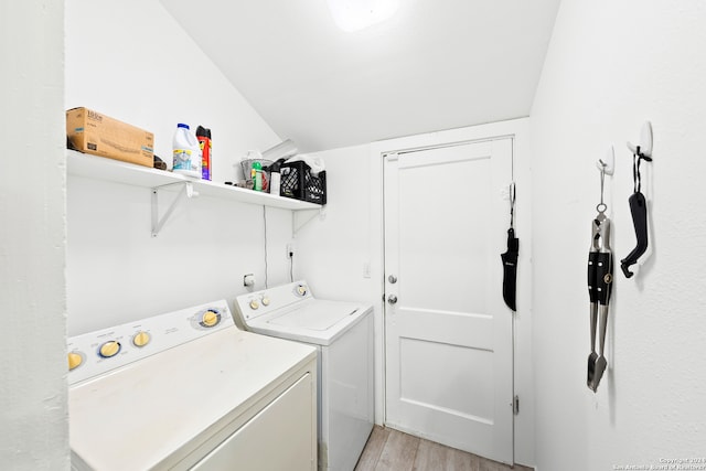 laundry room with washer and dryer and light hardwood / wood-style flooring