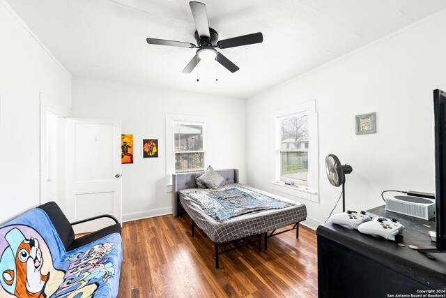 bedroom featuring ornamental molding, ceiling fan, and dark hardwood / wood-style flooring