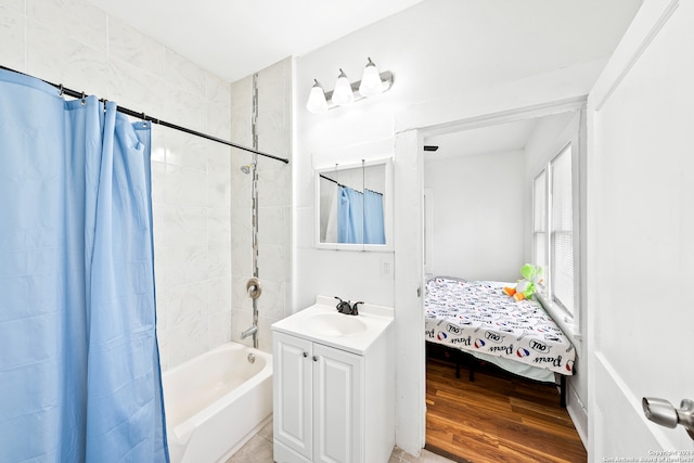 bathroom with hardwood / wood-style floors, shower / bath combo with shower curtain, and vanity with extensive cabinet space