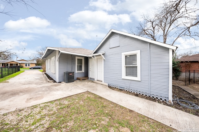 view of front of house with central AC and a patio