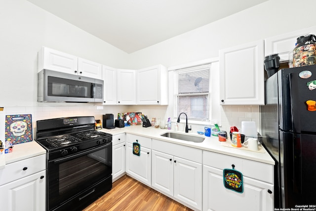 kitchen with sink, white cabinets, backsplash, light hardwood / wood-style floors, and black appliances