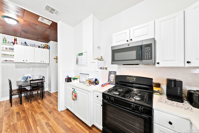 kitchen with black range, light hardwood / wood-style floors, tasteful backsplash, and white cabinetry