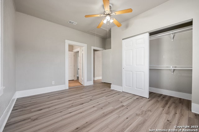 unfurnished bedroom with a closet, light hardwood / wood-style floors, and ceiling fan