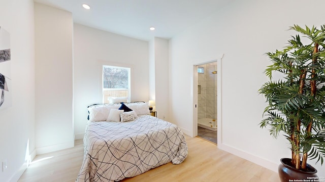 bedroom featuring connected bathroom and light hardwood / wood-style flooring