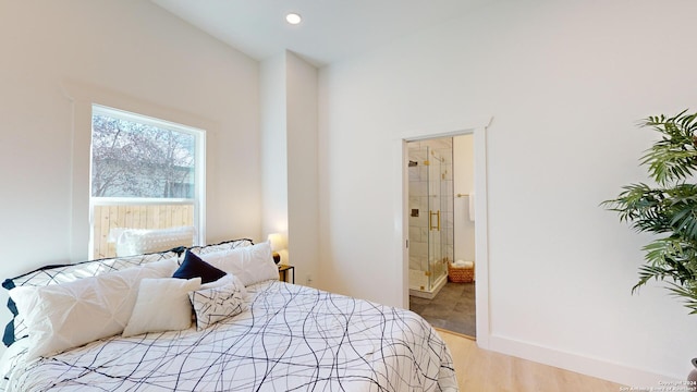 bedroom featuring ensuite bathroom and light wood-type flooring