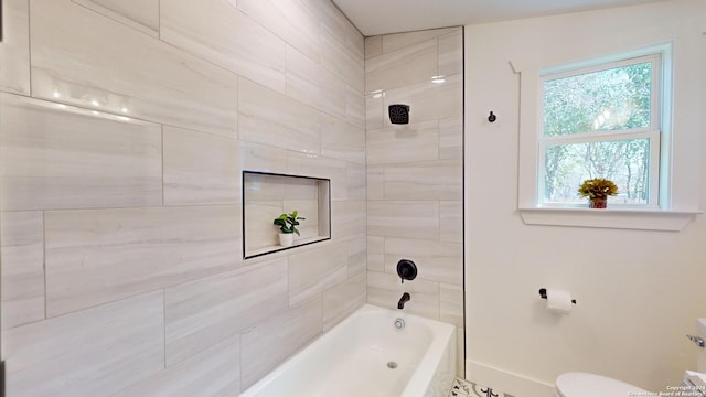 bathroom with toilet and tiled shower / bath combo