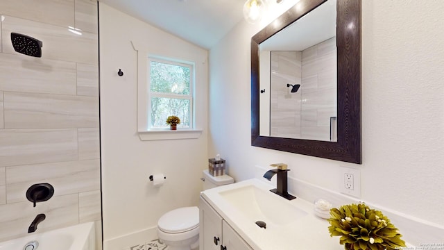 full bathroom with tiled shower / bath, toilet, vaulted ceiling, and vanity