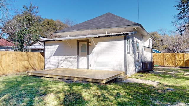 rear view of property featuring a lawn and a wooden deck