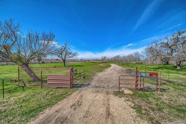 view of gate featuring a rural view and a yard