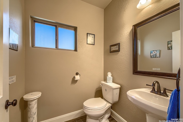 bathroom featuring toilet, tile floors, and sink