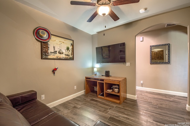 living room featuring ceiling fan, dark wood-type flooring, and lofted ceiling