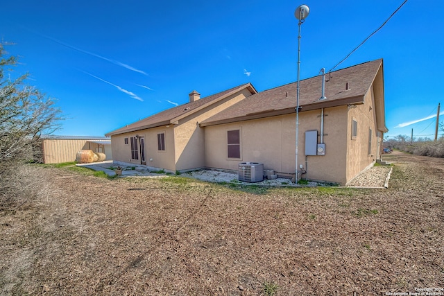 rear view of house with a shed and central AC unit