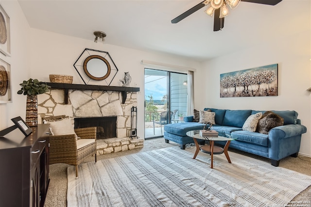 living room with light colored carpet, ceiling fan, and a fireplace