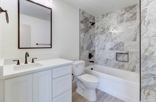 full bathroom with toilet, a textured ceiling, vanity, and tiled shower / bath