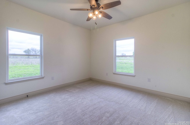 carpeted empty room with plenty of natural light and ceiling fan