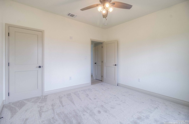 unfurnished room with ceiling fan and light colored carpet