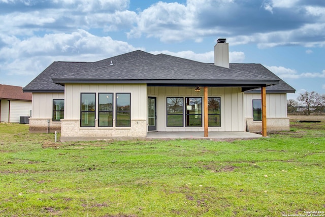 rear view of house with a patio, central AC, and a lawn