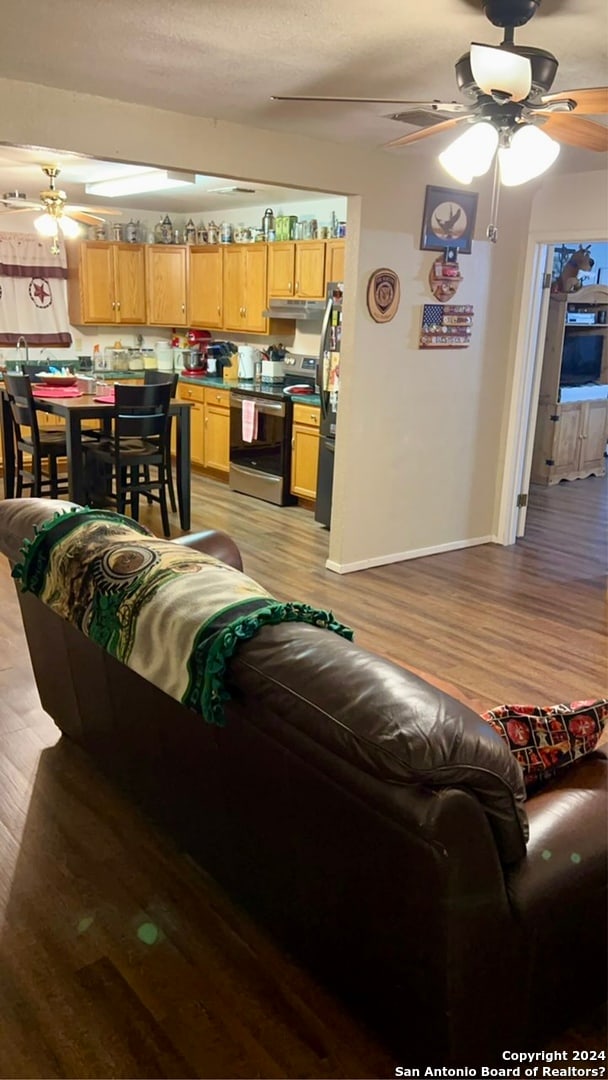 living room with ceiling fan and light hardwood / wood-style flooring