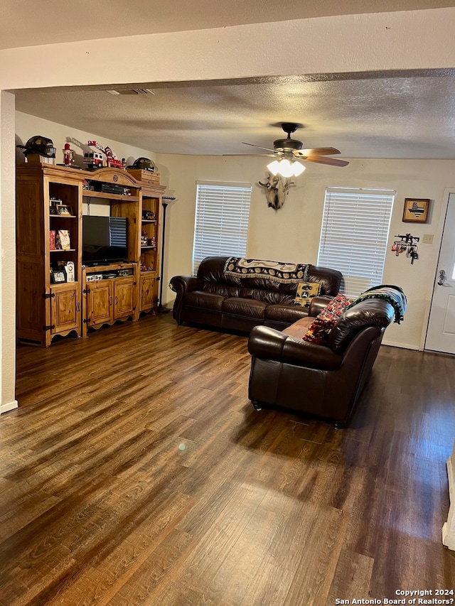 living room with dark hardwood / wood-style floors, a textured ceiling, and ceiling fan