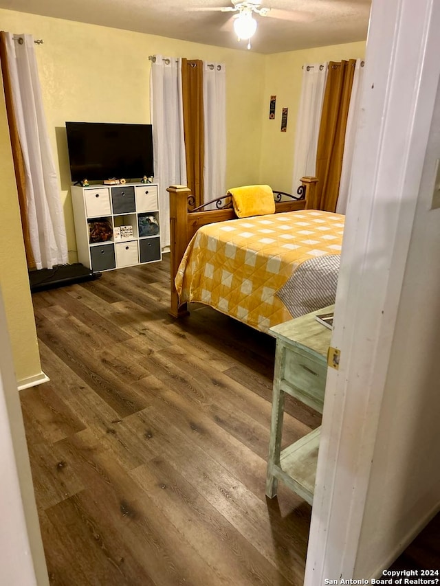 bedroom with ceiling fan and dark hardwood / wood-style floors