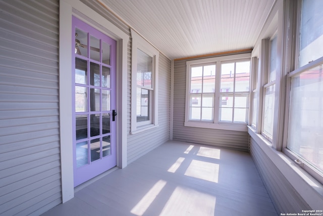 unfurnished sunroom with ceiling fan