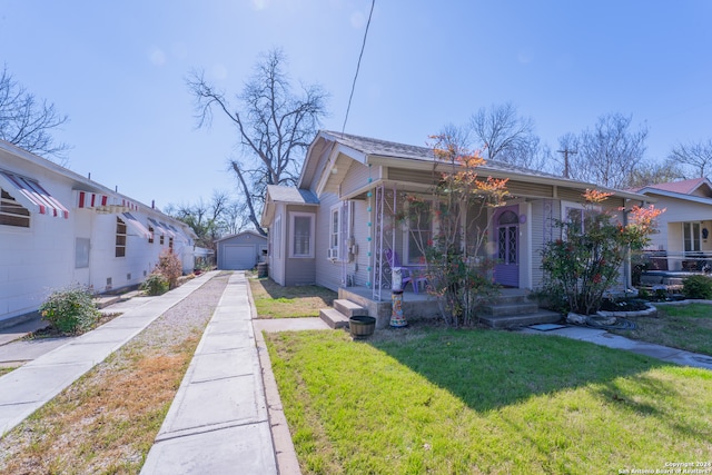 bungalow-style house featuring covered porch, a front lawn, and a garage