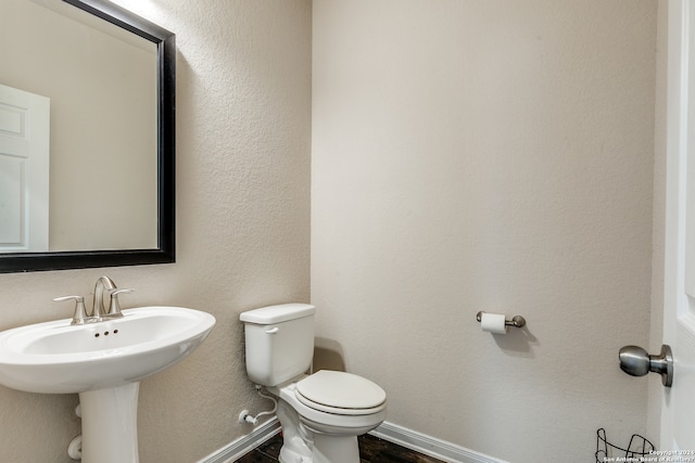 bathroom featuring wood finished floors, toilet, and baseboards