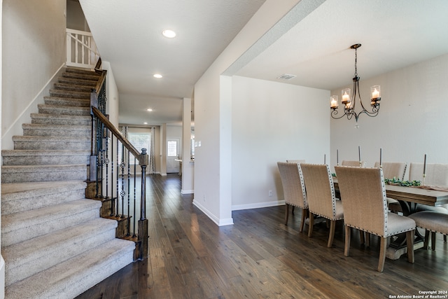 dining room with baseboards, visible vents, stairway, dark wood-type flooring, and an inviting chandelier