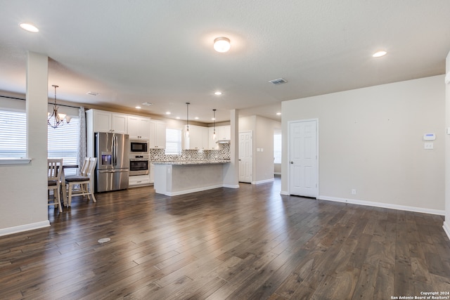 living area featuring baseboards, visible vents, dark wood finished floors, and a chandelier