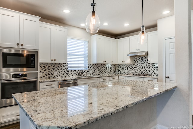 kitchen featuring tasteful backsplash, light stone countertops, stainless steel appliances, under cabinet range hood, and white cabinetry