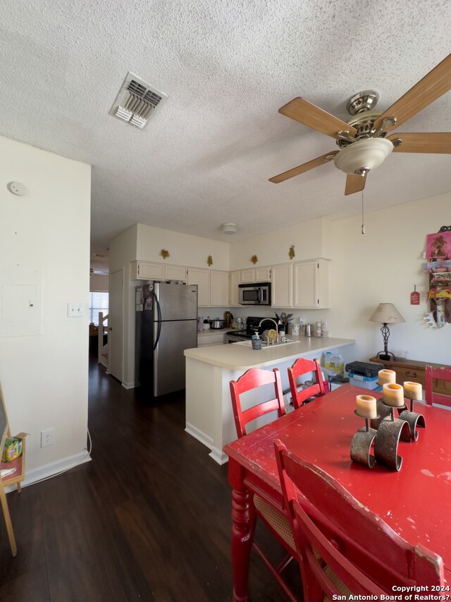 dining room with ceiling fan, a textured ceiling, and dark hardwood / wood-style flooring