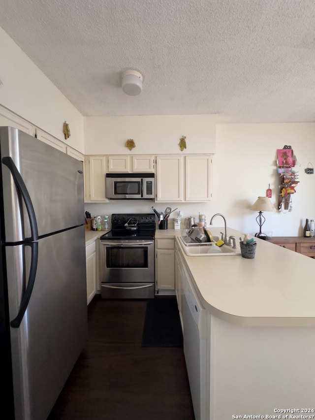 kitchen featuring kitchen peninsula, sink, stainless steel appliances, and dark hardwood / wood-style flooring