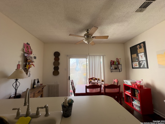 dining space with a textured ceiling, ceiling fan, and sink