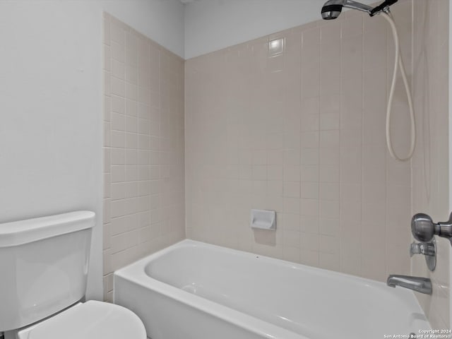 bathroom featuring tiled shower / bath and toilet